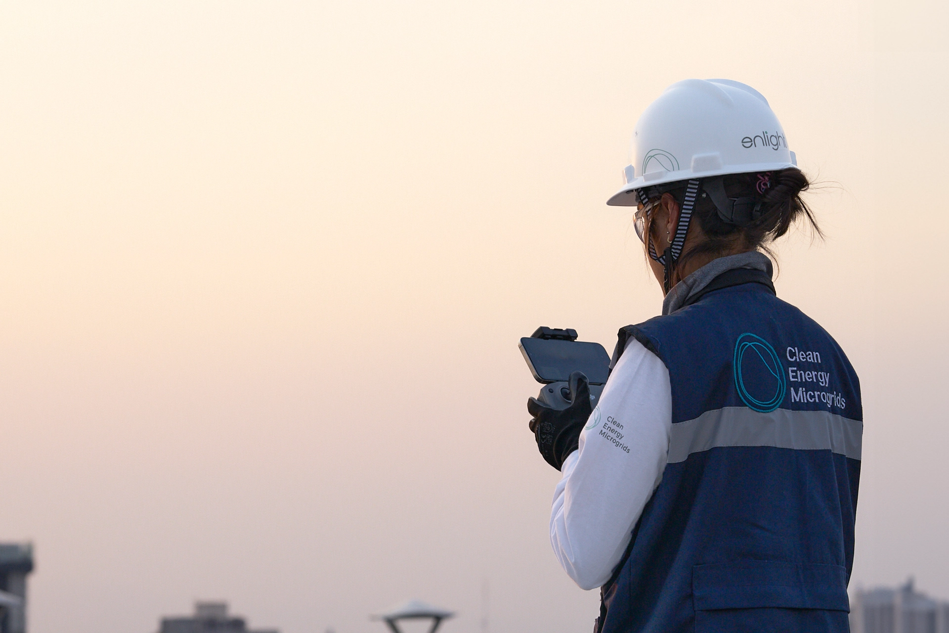 Enlight technician operating a drone over a solar installation in Mexico City at sunset